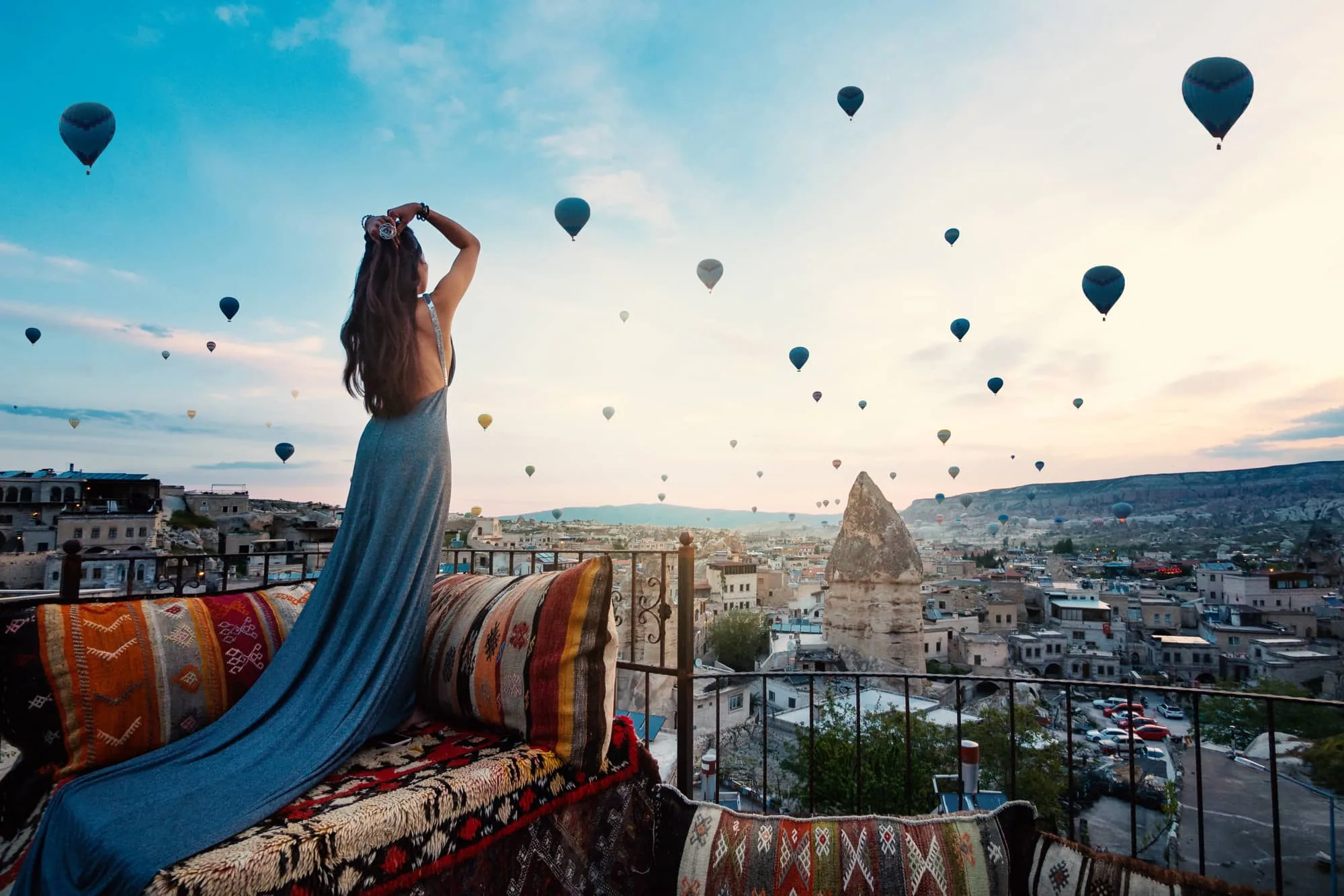 Viajera contemplando globos aerostáticos sobre Capadocia en Turquía